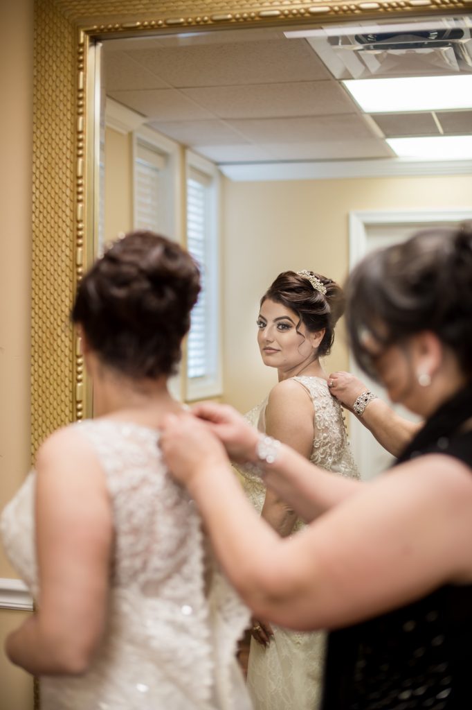 Brides mom closing her dress