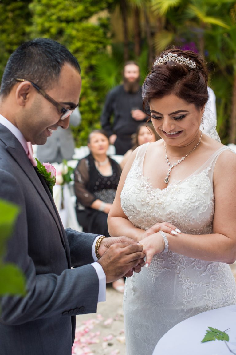 Groom putting ring on bride