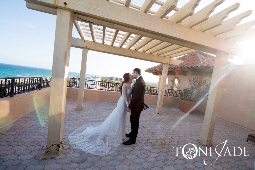 bride and groom kissing on rooftop