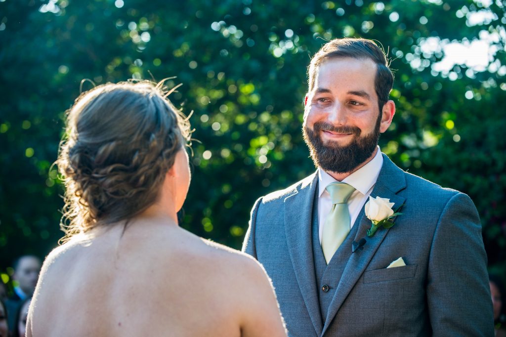 groom smiling at bride during ceremony