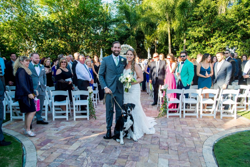 bride and groom walking down the aisle with their dog