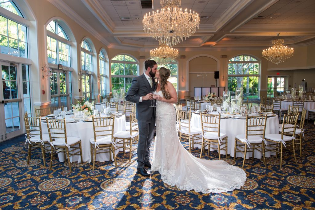 bride and groom kiss in reception room