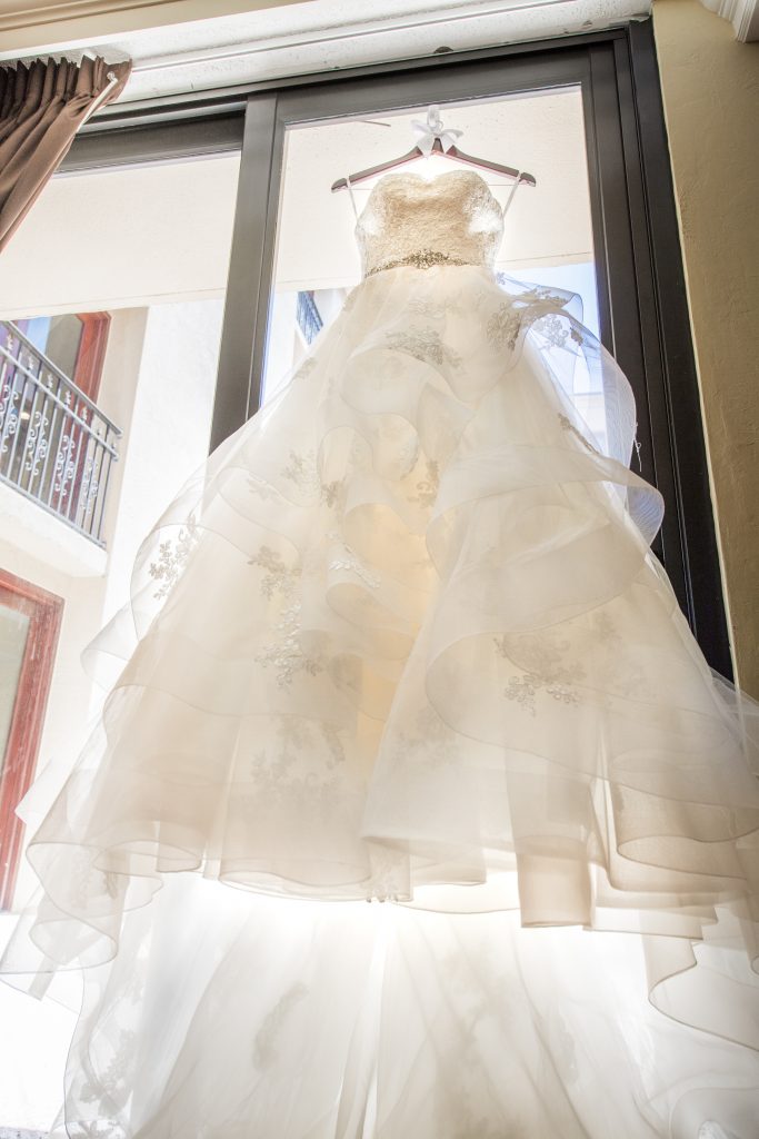 bride wedding dress hanging in window