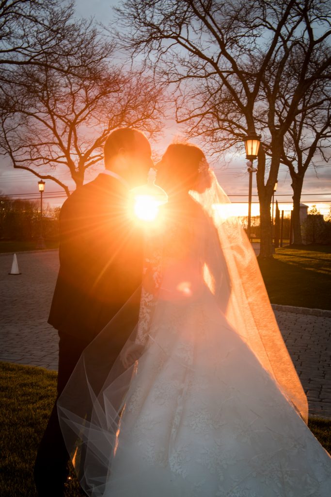 bride and groom kiss at sunset