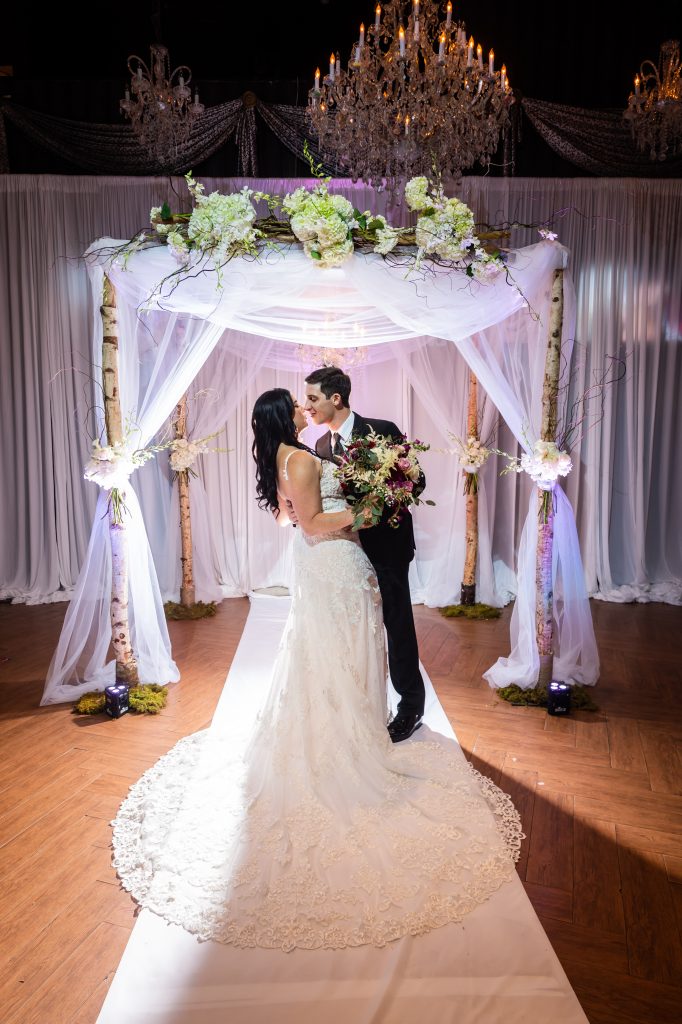 bride and groom with their chuppah