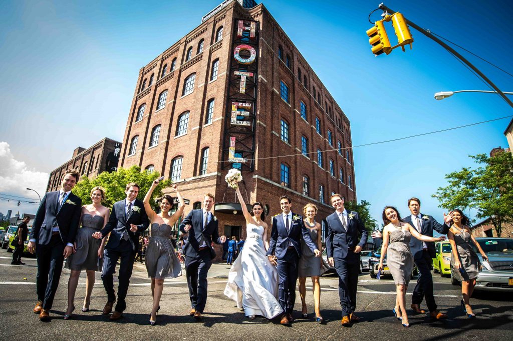 Bridal party walking in street in front of hotel