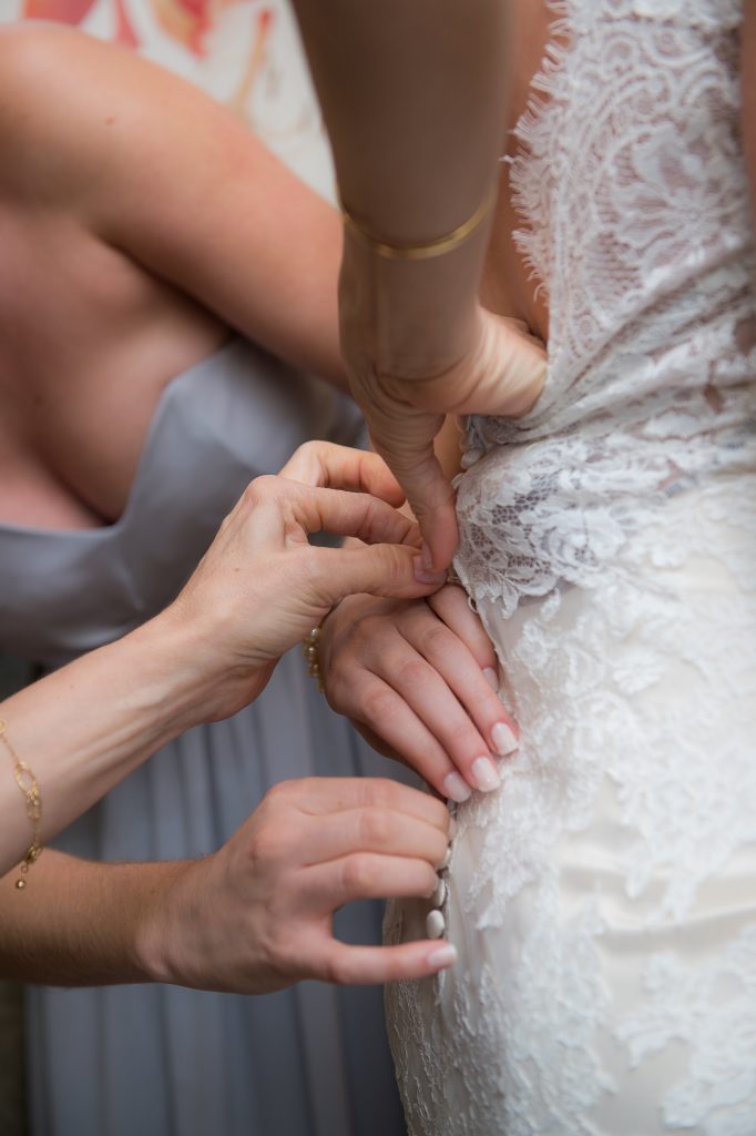 All hands fastening up brides dress