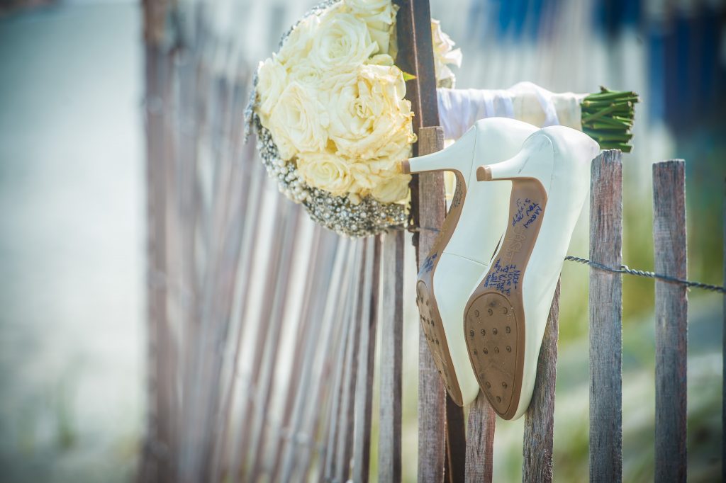 Wedding shoes hanging on fence