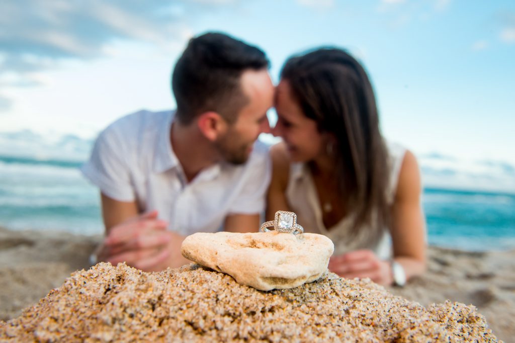 Engaged couple on beach with engagement ring