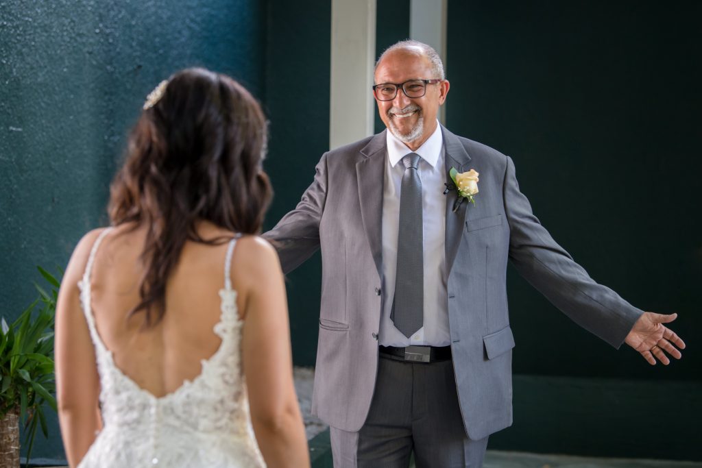 Father of bride with arms open during first look