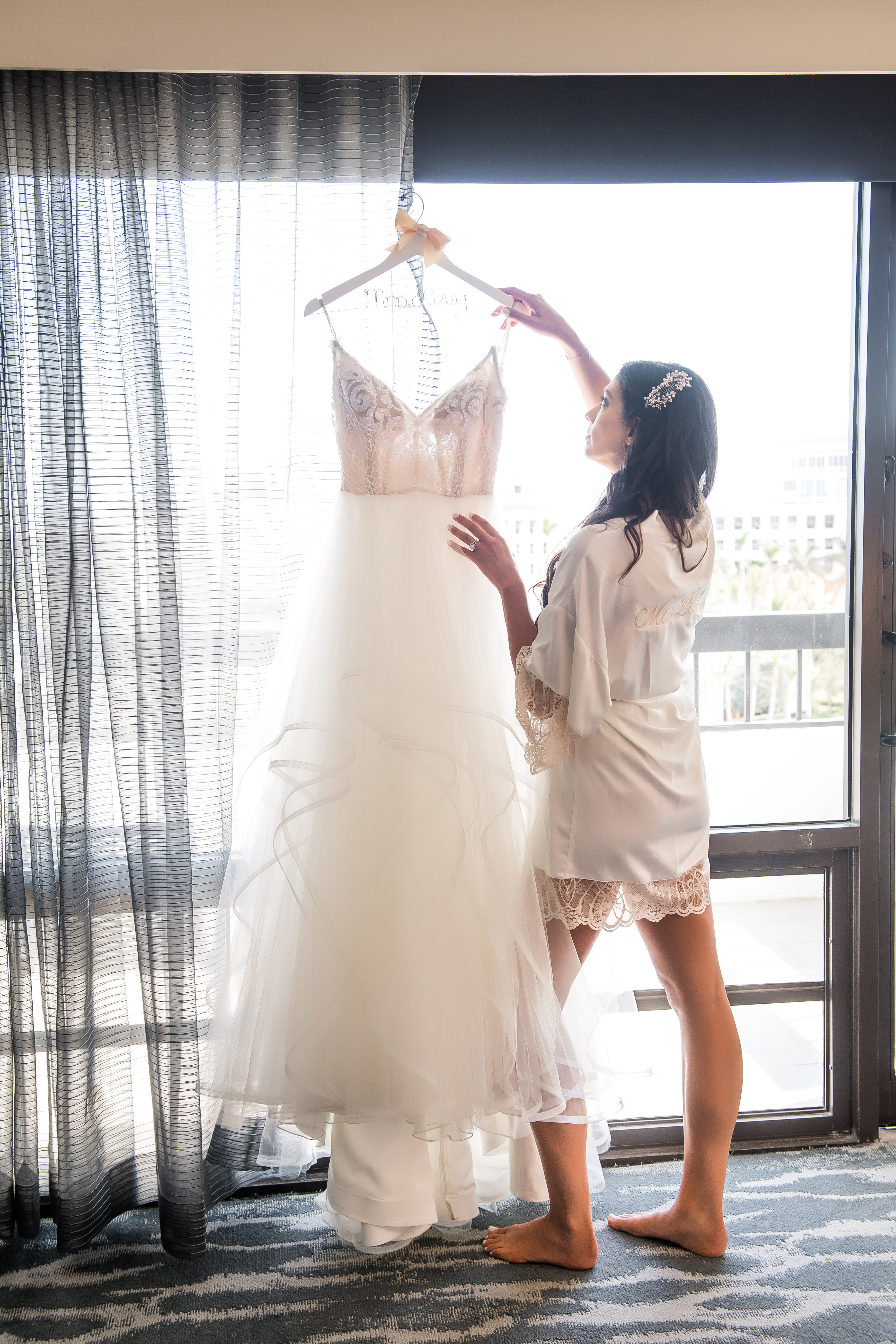 Bride hanging up wedding dress