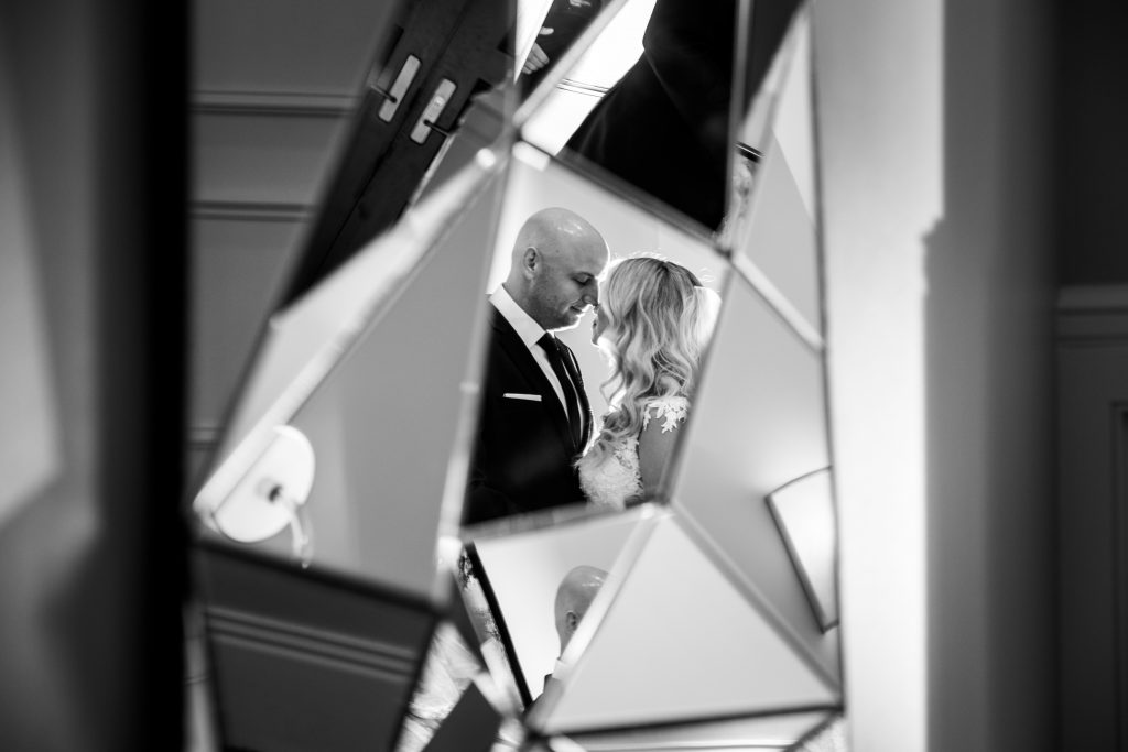 Bride and groom kissing in mirror