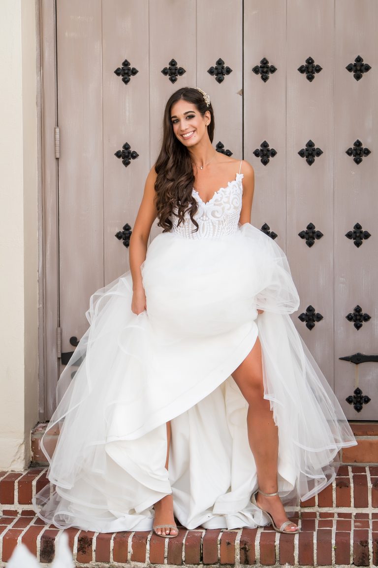 Bride against door with hiked up dress
